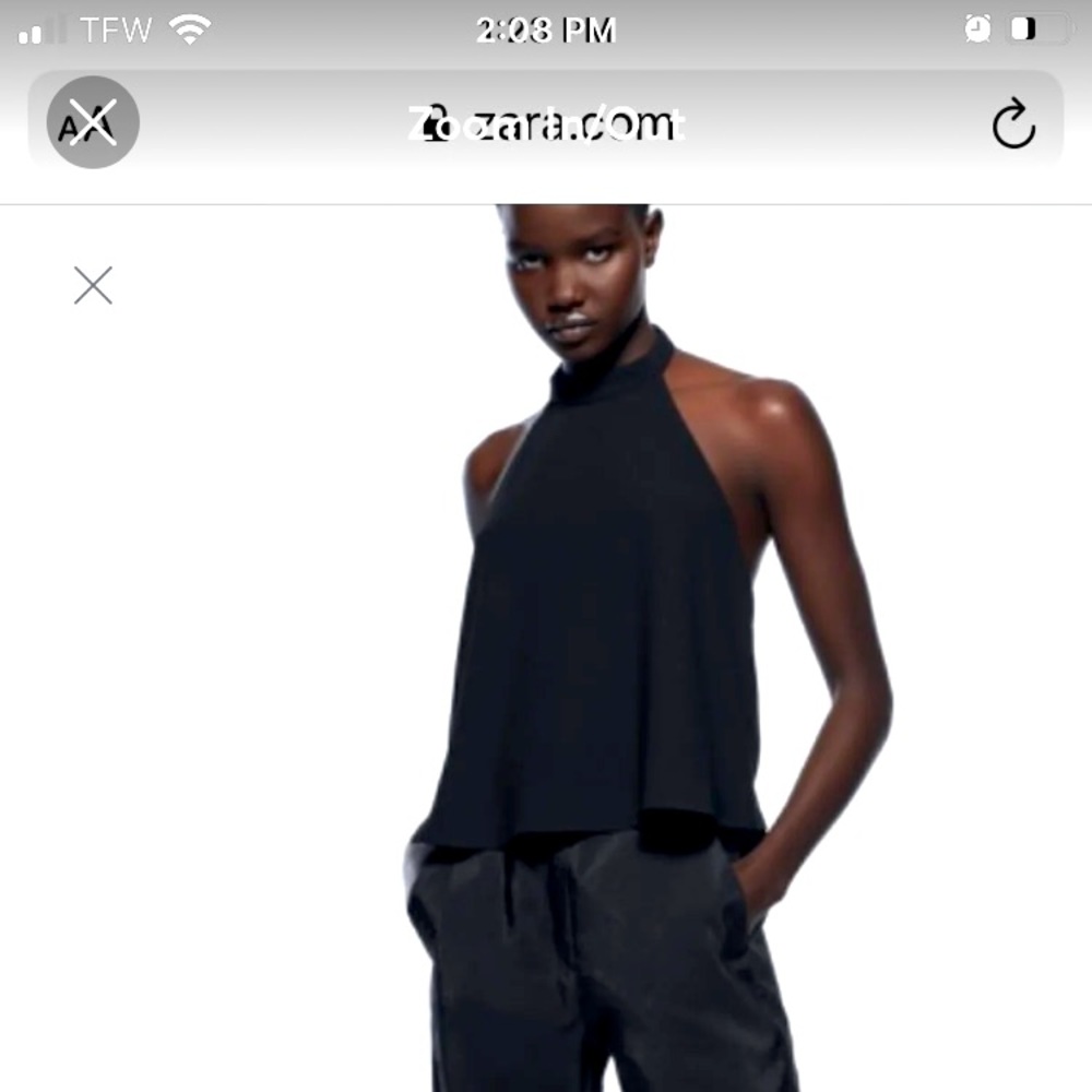 Halter top with open back. Back button closure.
Black .